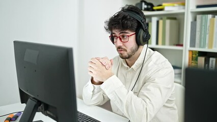 Wall Mural - Young hispanic man student smiling confident having video call at library university