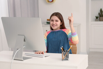 Canvas Print - Cute girl using computer at desk in room. Home workplace