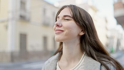 Poster - Young hispanic woman smiling breathing at street