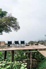 Wall Mural - chair on balcony with mountain hill and foggy background