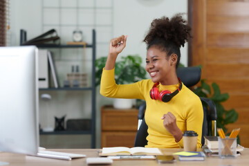 Happy young black woman raising hands with victory smiling happily with laptop computer. The concept of success at work.