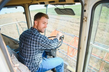 Wall Mural - Farmer driving combine and harvesting crop.