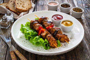 Wall Mural - Meat skewers - grilled meat with vegetables on wooden background
