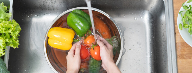 Wall Mural - people washing raw vegetables at sink in the kitchen prepare ingredient for cooking