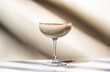 Brandy alexander alcoholic cocktail with cognac, cocoa liquor, cream, grated nutmeg and ice. Light beige background, hard light, shadow pattern. Minimalism