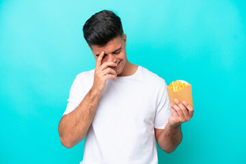 Poster - Young caucasian man catching french fries isolated on blue background laughing