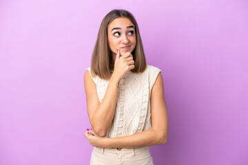 Wall Mural - Young caucasian woman isolated on purple background thinking an idea while looking up