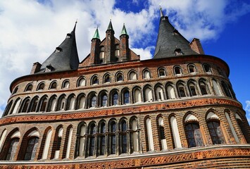 Canvas Print - Low angle shot of the Museum Holstentor exterior against a blue sky in Lubeck, Germany