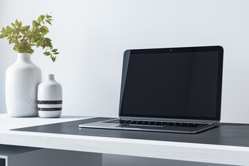 Poster - Close up of empty mock up laptop screen on desktop with flower in vase and concrete wall background. Designer desktop and ad concept. 3D Rendering.