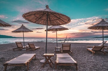 Wall Mural - Sunbeds and parasols on beach in Sarande, Albania during sunset afternoon