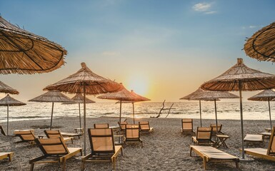 Sticker - Sunbeds and parasols on beach in Sarande, Albania during sunset afternoon