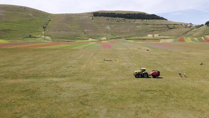 Sticker - Drone footage over a green field with a tractor. Castelluccio, Umbria, central Italy.