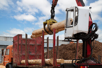 Wall Mural - Loading logs onto a logging truck. Portable crane on a logging truck.