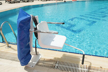Disabled person pool lift. Swinging arm disabled chair. Swimming pool lift with a chair. Solution for community and hospitality swimming pools.