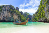 Fototapeta Uliczki - The Thai traditional wooden longtail boat and beautiful beach in Phuket province, Thailand.