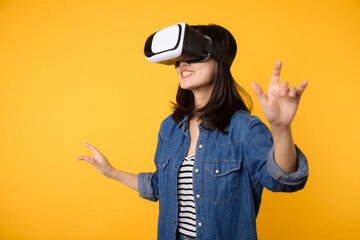 Poster - Young asian woman get experienced wearing virtual reality headset game entertainment isolated on yellow background. Winner of cyber future video game concept.