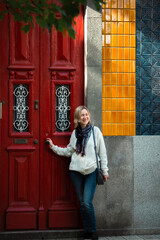 Wall Mural - A woman stands waiting at the door of a traditional house in Porto, Portugal.