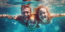 Father And Daughters Swimming Underwater In The Pool.