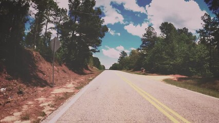 Wall Mural - Rear POV FPV driving on a rural country curved road vintage faded film effect