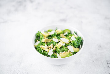 Wall Mural - Kale avocado pine nuts cheese salad with lemon dressing in a bowl