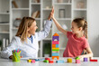 © Prostock-studio - Little Girl Giving High Five To Child Development Specialist, Celebrating Successful Therapy