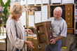 © JackF - Positive couple elderly customers buying wooden chest of drawers in a household goods store