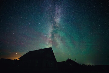 Wall Mural - stars sky and milky way above roofs in countryside