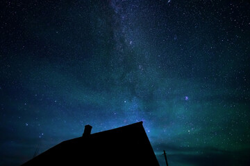 Wall Mural - stars sky and milky way above roofs in countryside