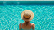 © PETR BABKIN - Woman in a hat by the pool looks at the water, back view. Generative Ai.
