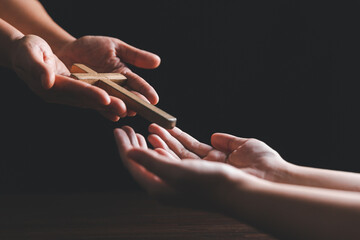 Wall Mural - Woman's hand with cross. Concept of hope, faith, christianity, religion, church online. Person holding christian cross to making pray indoors. Believe and faith for christian people.