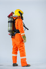 From a back view perspective the professional firefighter stands with unwavering poise clutching an iron axe firmly in hand their protective oxygen tank prominently visible.