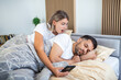 Woman is jealous and suspicious and spies in her partner's smartphone whiles he's sleeping in bedroom. The wife is spying on her husband's phone while he sleeps. The concept of distrust, jealousy