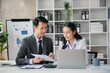 © laddawan - Asian business colleague business presents and explains and using laptop and tablet. Teamwork, financial marketing team, while sitting in office room.