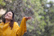 Happy woman standing with arms outstretched in rain