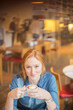 Woman drinking cup of coffee in cafe