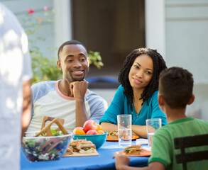 Wall Mural - Family eating lunch at patio table