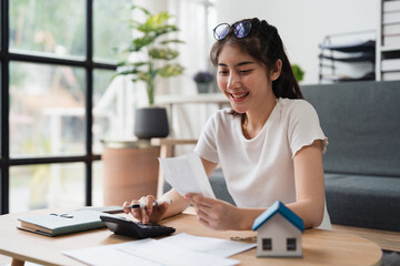 Asian accounting professional calculating household bills, reviewing and analyzing household bills, and filing tax returns