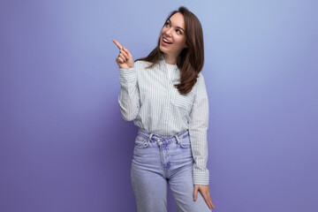 25 year old brown-haired female person dressed in a striped blouse points her index finger to the side