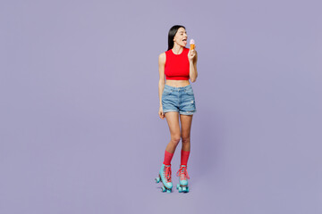 Full body happy fun young latin woman she wearing red casual clothes rollers rollerblading eat icecream close eyes isolated on plain pastel purple background. Summer sport lifestyle leisure concept.