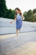 © Photocreo Bednarek - Young girl jumping playing hopscotch in urban neighborhood