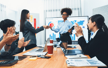 Wall Mural - Diverse coworker celebrate with handshake and teamwork in corporate workplace. Happy business people united by handshaking after successful meeting or business presentation on data analysis. Concord