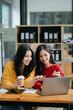 © Nuttapong punna - Two Attractive young Asian female college students working on the school project using laptop computer and tablet together, enjoy talking
