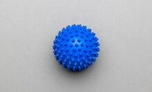 Close-up Top View Of A Spikey Blue Massage Ball Over The Gray Surface
