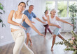 © JackF - Group of happy mature sports women and man in activewear exercising dynamic dancing movemens in modern gym studio