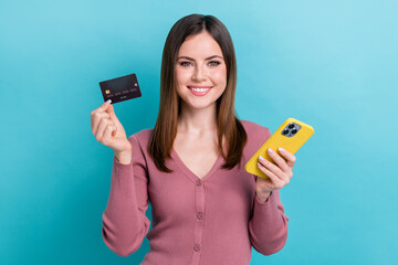 Poster - Photo of young digital blogger girl wear pink shirt hold phone demonstrate nfc card payment ebank isolated on cyan color background