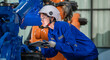 © BESTIMAGE - woman engineer in uniform helmet inspection check control heavy machine robot arm construction installation in industrial factory. technician worker check for repair maintenance electronic operation