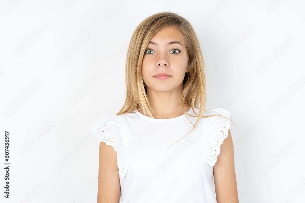 Stunned beautiful caucasian teen girl wearing white T-shirt over white ...