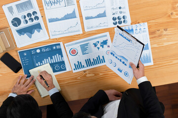 Poster - Top view analyst team discussing financial data on digital dashboard, analyzing chart and graph papers by data science software on wooden table background. Business intelligence and Fintech. Fervent