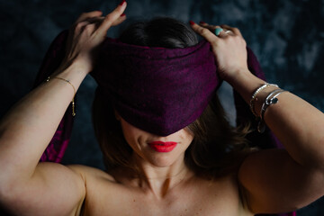 portrait of young beautiful woman is having fun with a red scarf