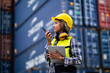 © KANGWANS - Female workers in the container industry transporting imports and exports of goods to the shipping business. Confident engineer in container terminal.